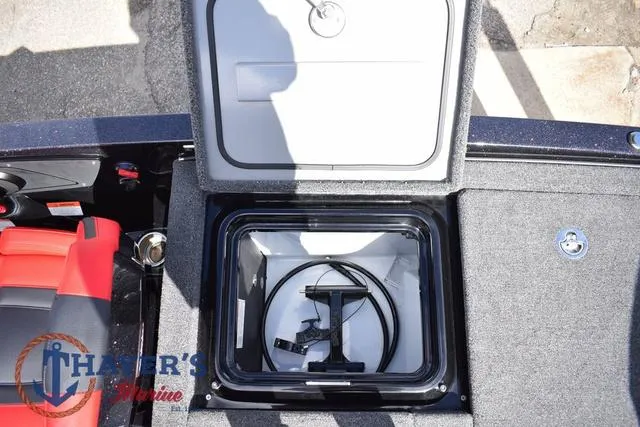 Slide: The Image of Open storage compartment on 2024 Ikon Boats LX21, featuring interior equipment and red seating. - 30