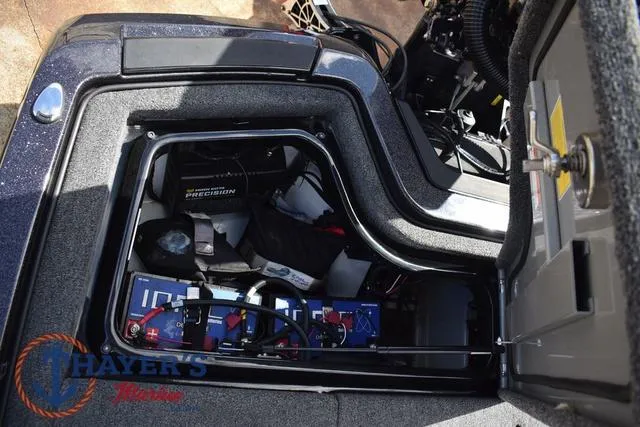 Slide: The Image of 2024 Ikon Boats LX21 battery compartment with wiring and storage space. - 31