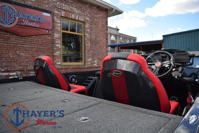 Slide: The Image of 2024 Ikon Boats LX21 interior with red and black seats at Thayer's Marine. - 9