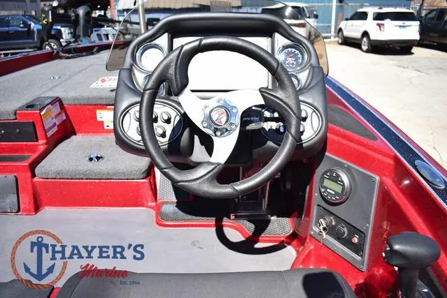 Slide: The Image of 2021 Triton 18 TrX boat dashboard with steering wheel and control panel. - 15