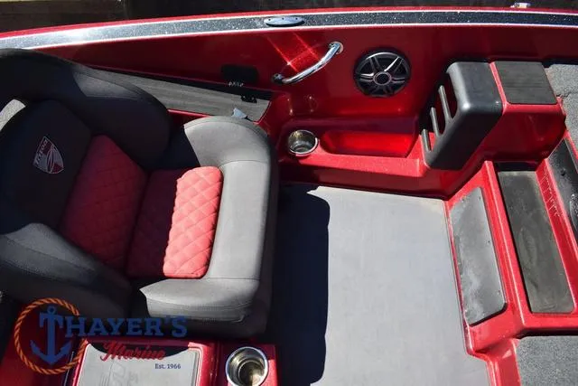 Slide: The Image of 2021 Triton 18 TrX boat interior with red and black seating, cup holders, and speaker. - 16