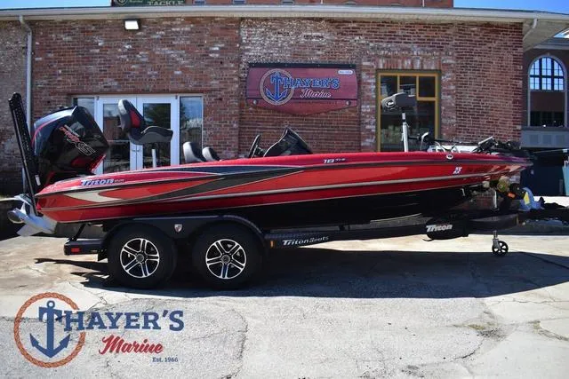 Slide: The Image of 2021 Triton 18 TrX boat in red, parked at Thayer's Marine dealership. - 2