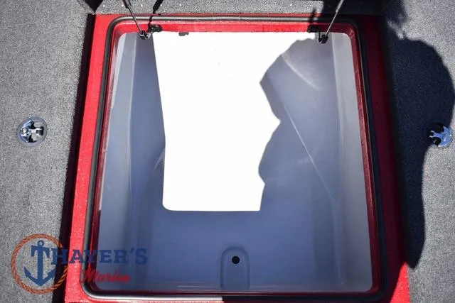 Slide: The Image of Open storage compartment in 2021 Triton 18 TrX boat, red trim, gray interior. - 21