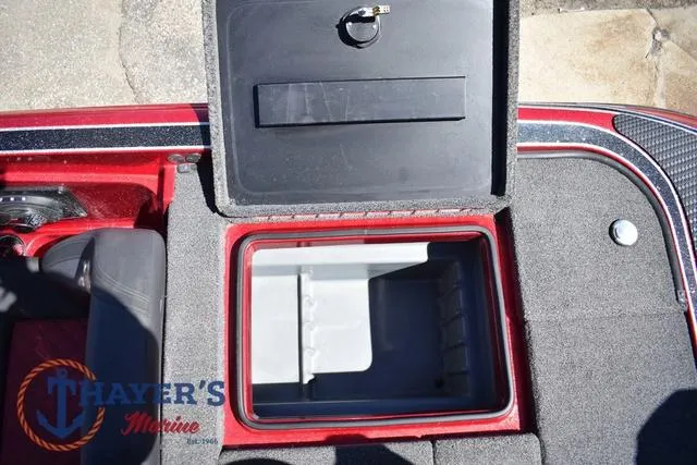 Slide: The Image of Open storage compartment on 2021 Triton 18 TrX boat, featuring carpeted interior and secure latch. - 27