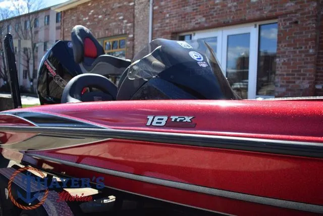 Slide: The Image of Red 2021 Triton 18 TrX boat parked outdoors, showcasing sleek design and branding. - 37