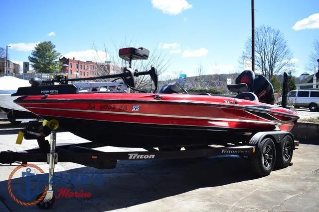 Slide: The Image of 2021 Triton 18 TrX boat in red, parked on a trailer outdoors. - 6