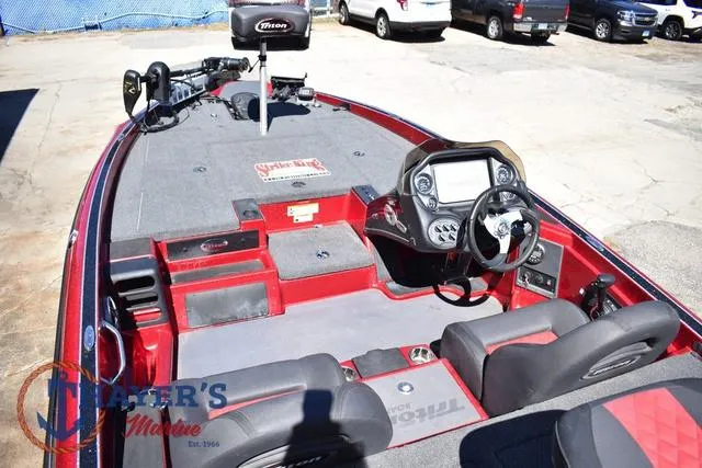 Slide: The Image of 2021 Triton 18 TrX boat interior with steering console and seating, displayed outdoors. - 9