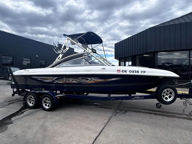 Slide: The Image of 2008 Tigé 24 VE boat with cover on trailer under cloudy sky. - 1