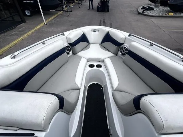Slide: The Image of 2008 Tigé 24 VE boat interior with white and navy seating, cup holders, and speakers. - 13