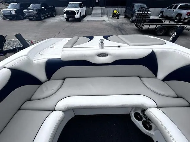 Slide: The Image of 2008 Tigé 24 VE boat interior with white and navy seating, parked in a lot. - 19