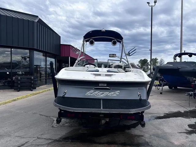 Slide: The Image of 2008 Tigé 24 VE boat interior with white and navy seating, parked in a lot. - 3
