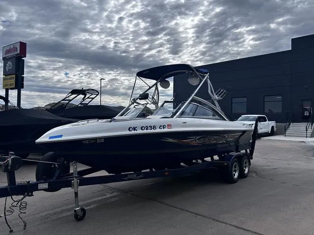 Slide: The Image of 2008 Tigé 24 VE boat on trailer, parked outdoors under cloudy sky. - 5