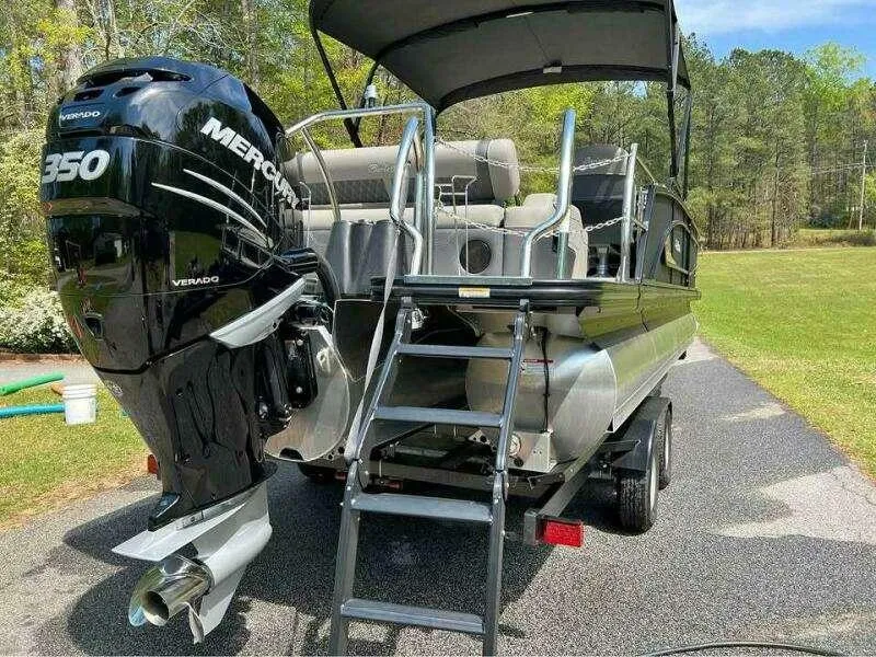 Slide: The Image of 2023 Barletta LUSSO 25U pontoon boat with Mercury 350 Verado engine on trailer. - 1