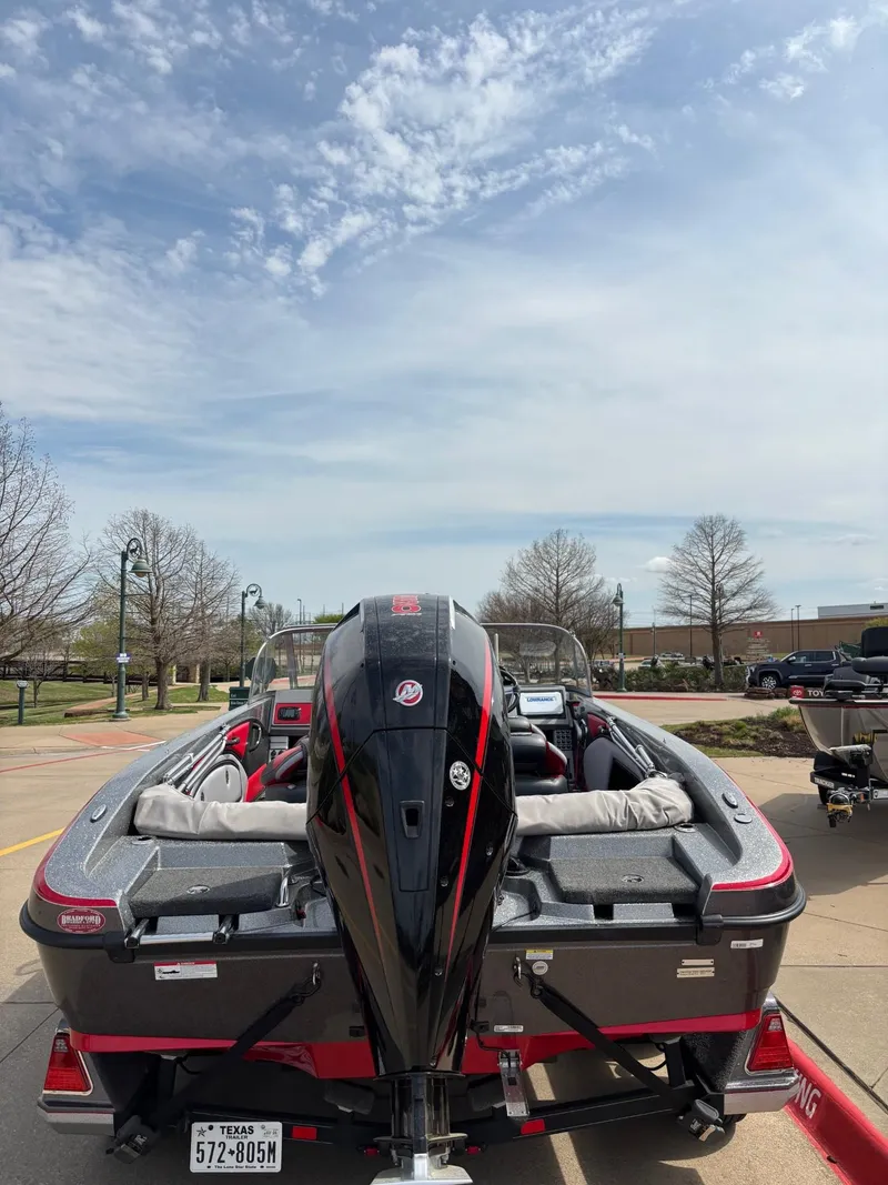 Slide: The Image of 2022 Ranger 2050MS boat with outboard motor, parked outdoors under a partly cloudy sky. - 4