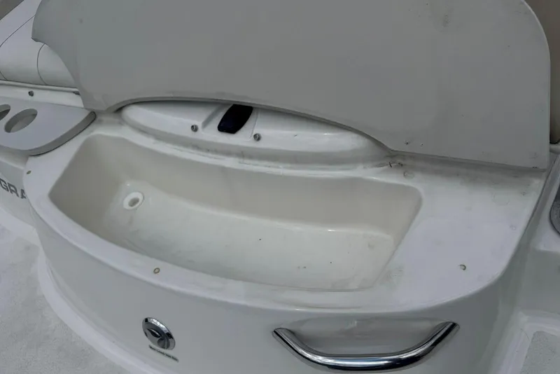Slide: The Image of 2017 Stingray 235 LR boat interior with storage compartment and cup holders. - 10