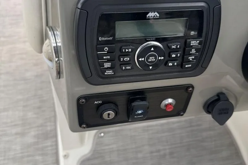 Slide: The Image of Control panel of a 2017 Stingray 235 LR boat with audio system and switches. - 23