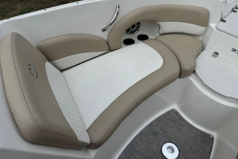 Slide: The Image of 2017 Stingray 235 LR boat interior with beige and white cushioned seating. - 26