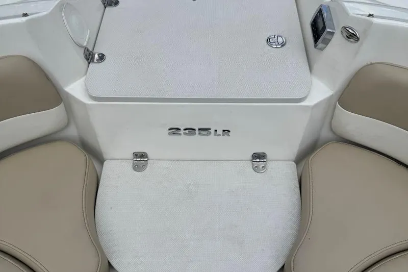 Slide: The Image of 2017 Stingray 235 LR boat interior with beige seating and storage compartments. - 27
