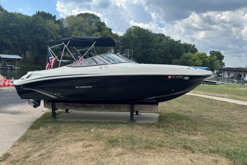 Slide: The Image of 2017 Stingray 235 LR boat on display, black and white design, with canopy, outdoors. - 3