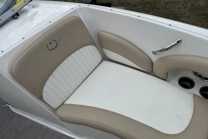 Slide: The Image of 2017 Stingray 235 LR boat seat with beige and white upholstery, featuring logo and cup holders. - 36