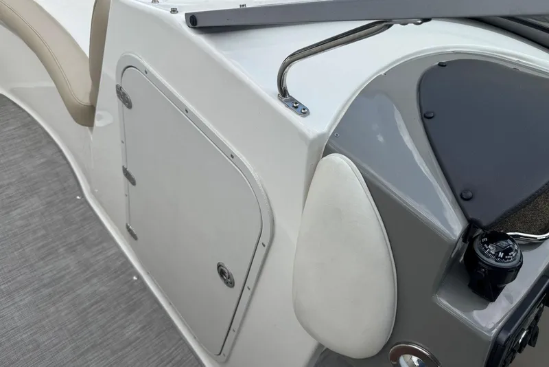 Slide: The Image of 2017 Stingray 235 LR boat interior with storage compartment and compass. - 37