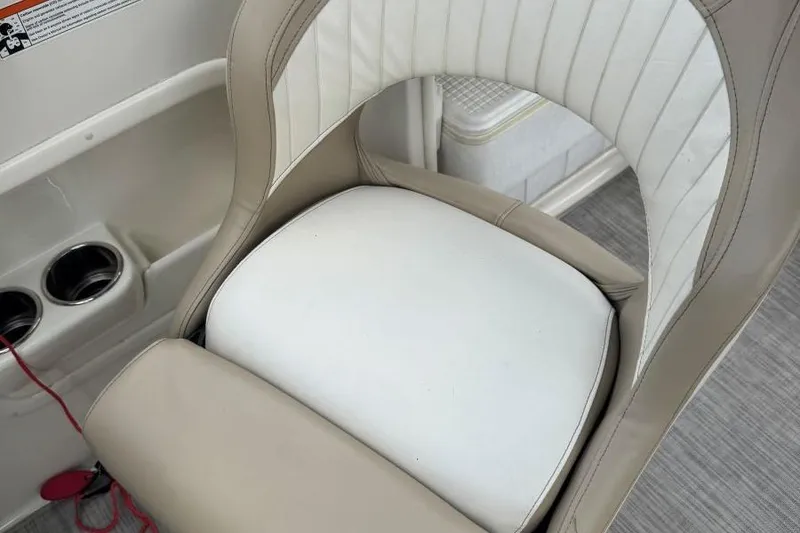 Slide: The Image of 2017 Stingray 235 LR boat seat with beige and white upholstery, cup holders visible. - 41