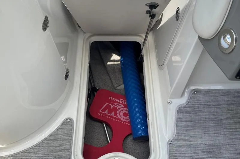 Slide: The Image of Storage compartment in a 2017 Stingray 235 LR boat with blue and red accessories. - 46