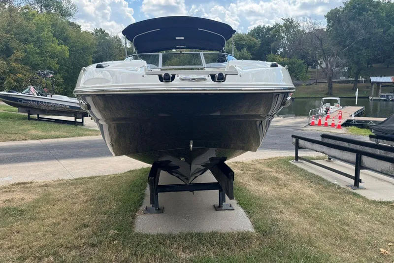 Slide: The Image of 2017 Stingray 235 LR boat on display near a lakeside dock. - 5