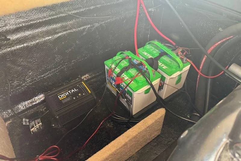 Slide: The Image of 2017 Stingray 235 LR boat battery compartment with dual Interstate batteries and digital charger. - 51