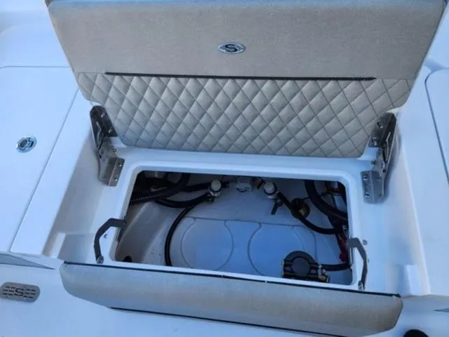 Slide: The Image of Open storage compartment on 2025 Sportsman MASTERS 247OE boat, featuring quilted upholstery. - 12