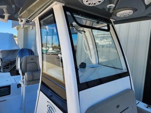Slide: The Image of 2025 Sportsman MASTERS 247OE boat interior with seating and console, featuring modern design elements. - 6