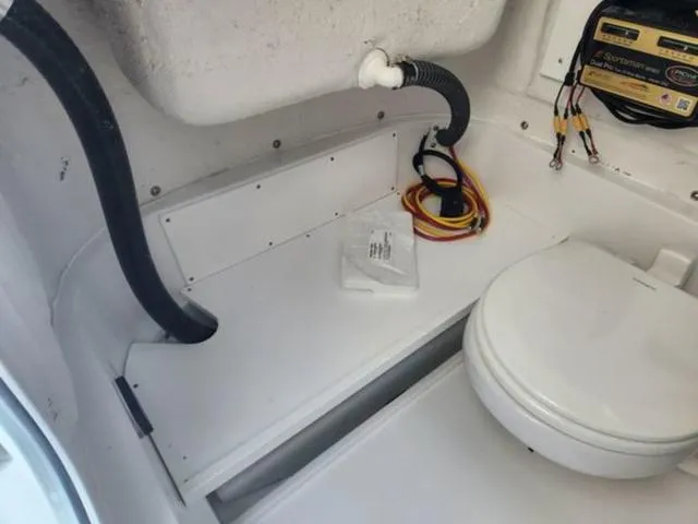 Slide: The Image of 2025 Sportsman Heritage 231 boat interior with toilet and wiring. - 12
