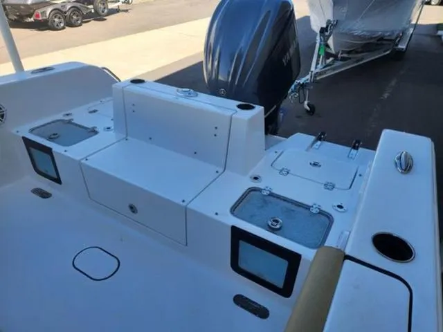 Slide: The Image of 2025 Sportsman Heritage 231 boat deck with storage compartments and outboard motor. - 17