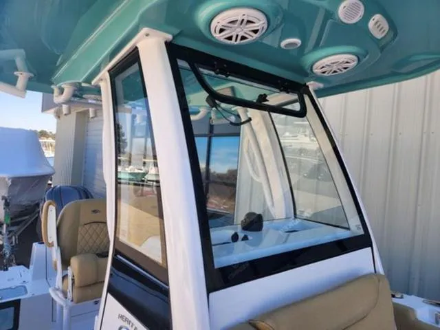 Slide: The Image of 2025 Sportsman Heritage 231 boat with teal canopy and beige seating. - 9