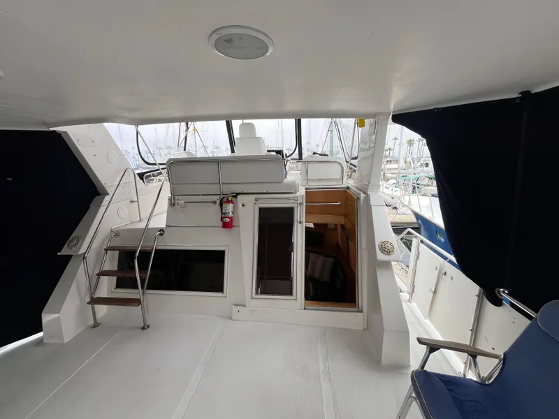 Slide: The Image of 1999 Ocean Alexander Sundeck 460 yacht interior with seating and stairs, featuring a modern design. - 10