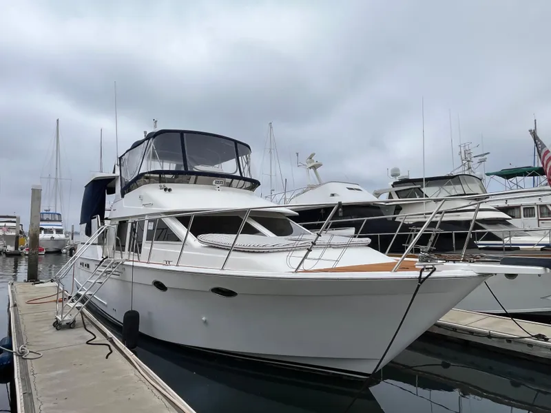 Slide: The Image of 1999 Ocean Alexander Sundeck 460 yacht docked at marina under cloudy sky. - 2