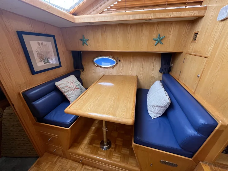 Slide: The Image of Cozy dining nook in 1999 Ocean Alexander Sundeck 460 with blue seating and wooden table. - 22