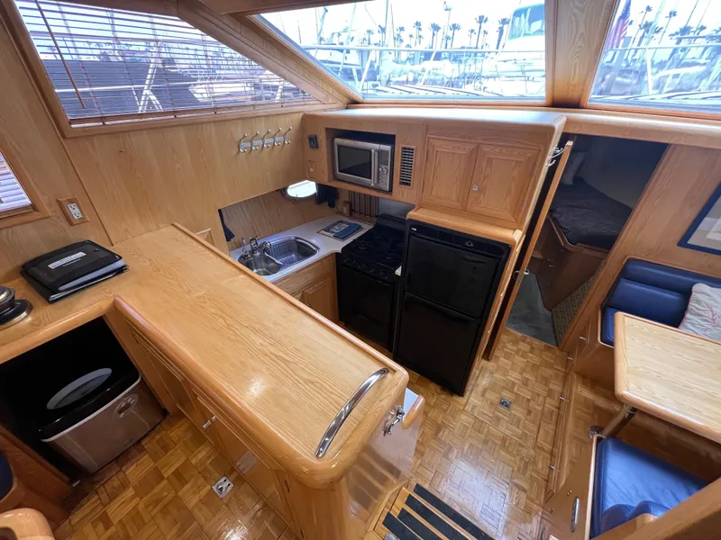 Slide: The Image of Interior of 1999 Ocean Alexander Sundeck 460 yacht, featuring kitchen and dining area. - 24