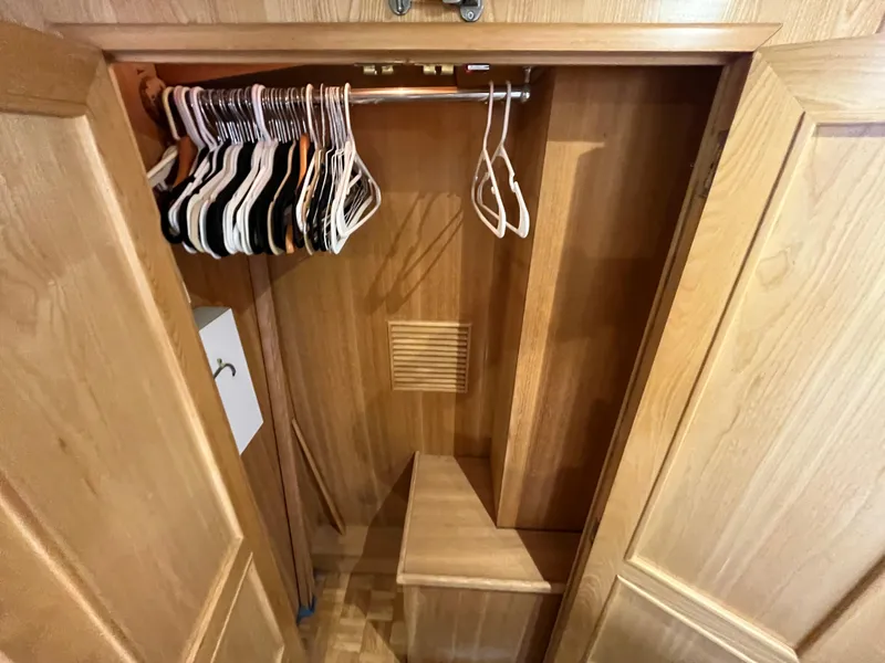 Slide: The Image of Wooden closet interior with hangers, part of a 1999 Ocean Alexander Sundeck 460 yacht. - 44