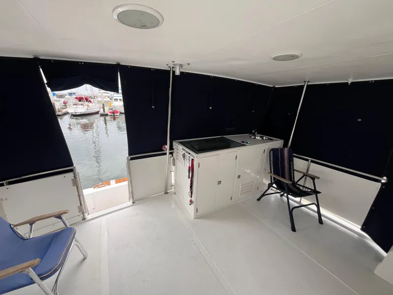 Slide: The Image of 1999 Ocean Alexander Sundeck 460 interior with seating and kitchenette, docked at marina. - 11