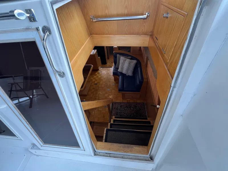 Slide: The Image of Interior view of 1999 Ocean Alexander Sundeck 460 yacht, featuring wooden stairs and seating area. - 17