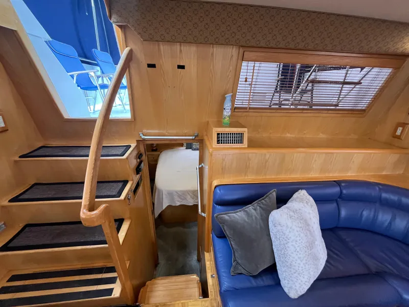 Slide: The Image of Interior of 1999 Ocean Alexander Sundeck 460 with blue seating and wooden stairs. - 20