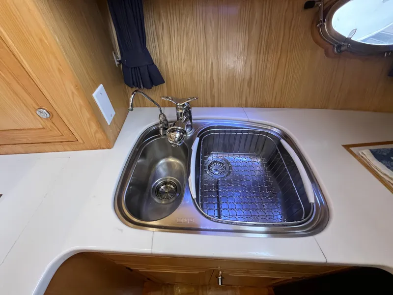 Slide: The Image of 1999 Ocean Alexander Sundeck 460 kitchen sink with dual basins and wooden cabinetry. - 29
