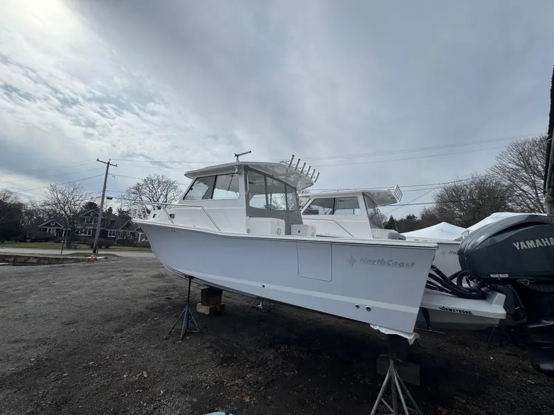 The Image of 2025 NorthCoast 315 HT boat on stands, overcast sky, Yamaha engine visible. - 0