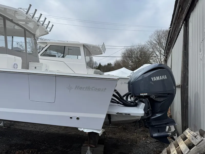 Slide: The Image of 2025 NorthCoast 315 HT boat with Yamaha outboard motor, parked outdoors. - 2