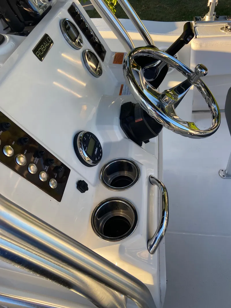 Slide: The Image of 2020 Robalo R202 EX boat dashboard with steering wheel and controls. - 10