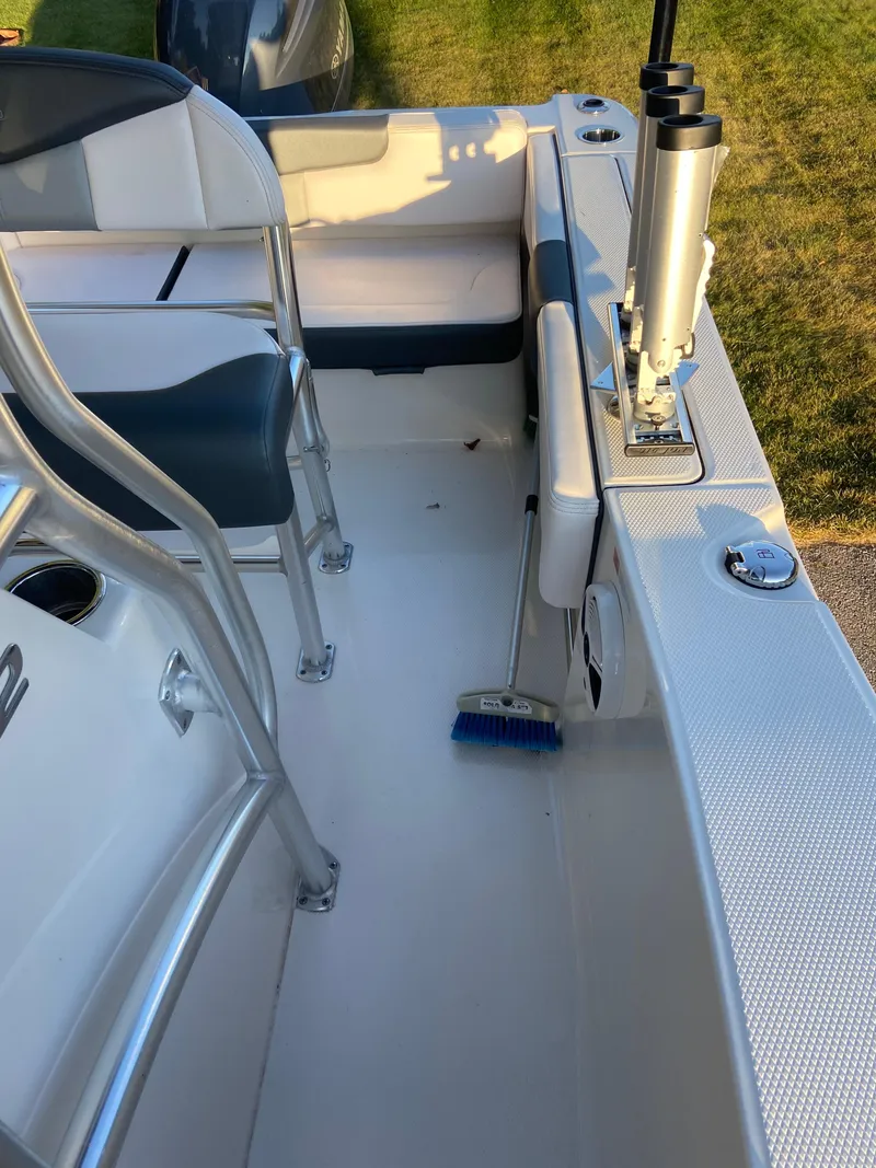 Slide: The Image of 2020 Robalo R202 EX boat interior with seating and cleaning brush on deck. - 9