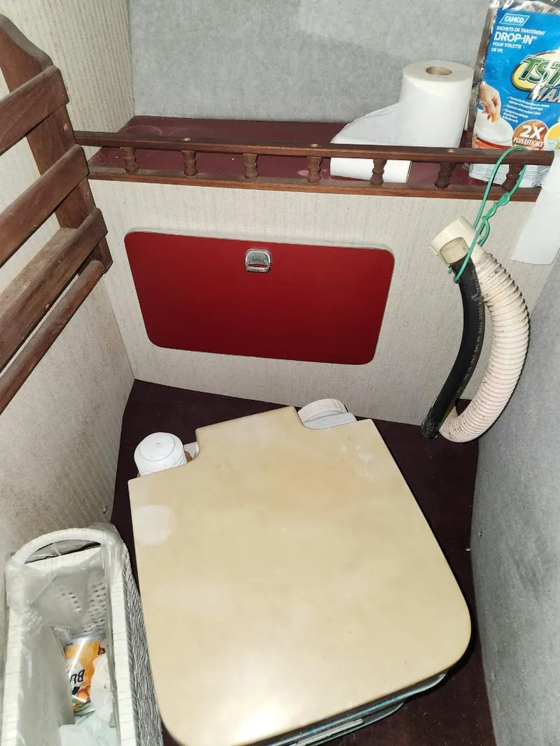 Slide: The Image of 1987 Larson 23 Cuddy Cabin interior with portable toilet and storage. - 10