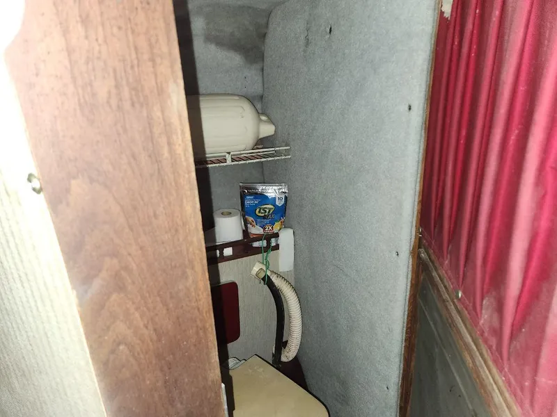 Slide: The Image of 1987 Larson 23 Cuddy Cabin interior with storage shelves and marine equipment. - 11