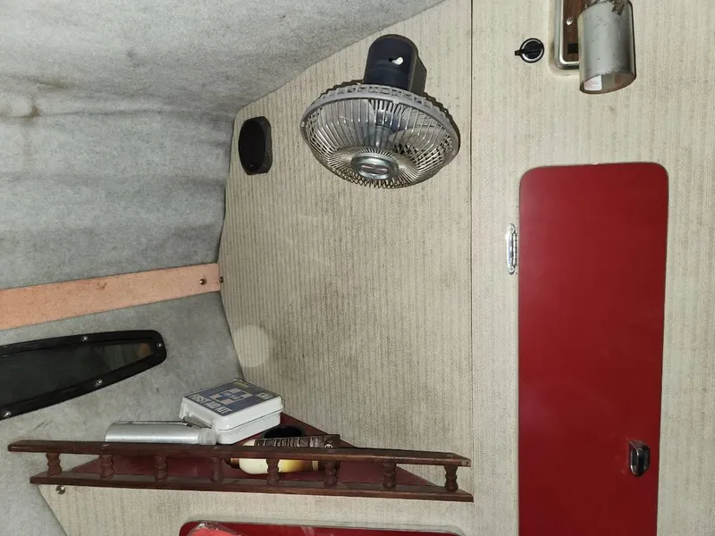 Slide: The Image of Interior of 1987 Larson 23 Cuddy Cabin boat with fan and storage shelf. - 13